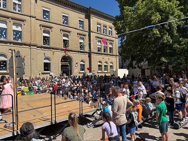 Blick auf das bunt Schulfesttreiben auf dem Pausenhof 