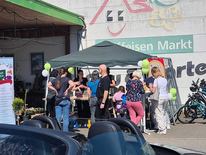 Menschen am Stand des Fördervereins am Raiffeisen-Markt