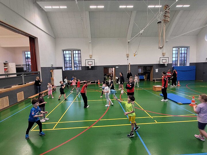 Schülerinnen und Schüler beim Werfen und Fangen