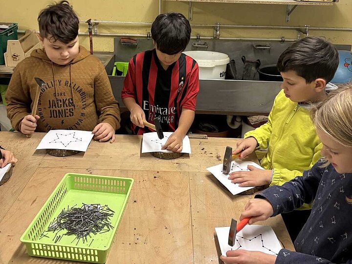 Kinder beim Einschlagen von Nägeln