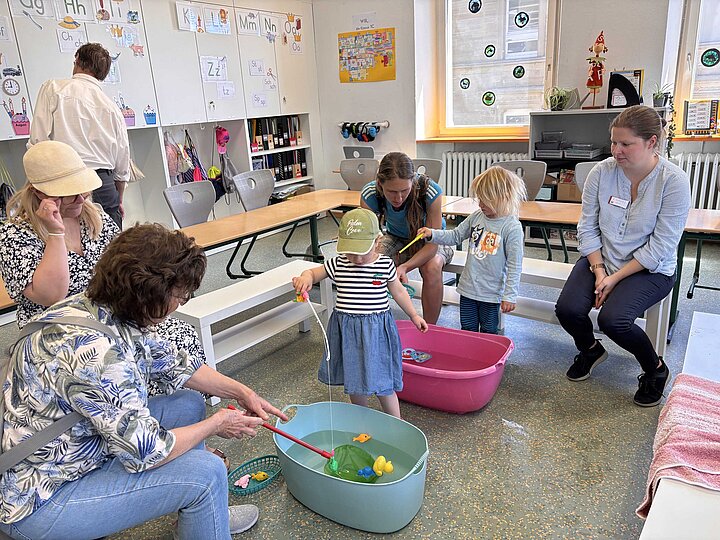 Kinder mit ihren Eltern beim Angelspiel