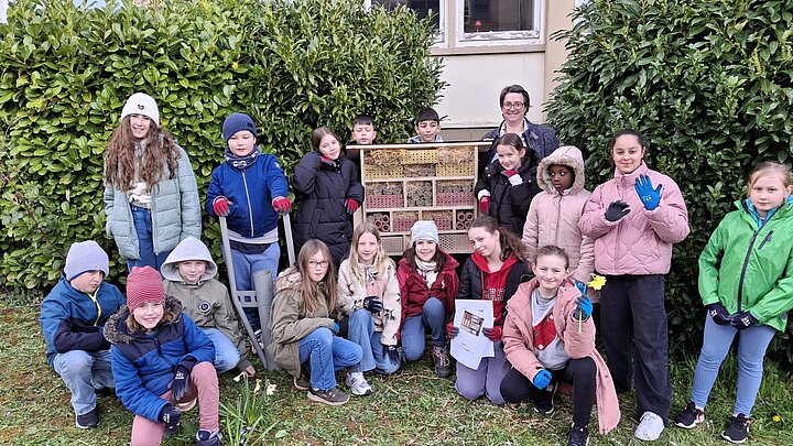 Schülerinnen und Schüler vor dem Insektenhotel