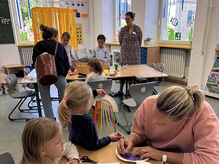 Schülerinnen mit Ihren Eltern beim Basteln