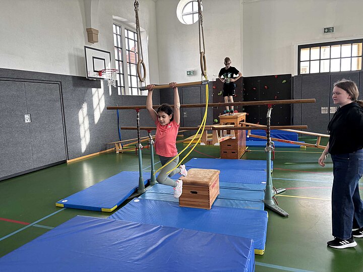Schülerin schwingt am Trapez