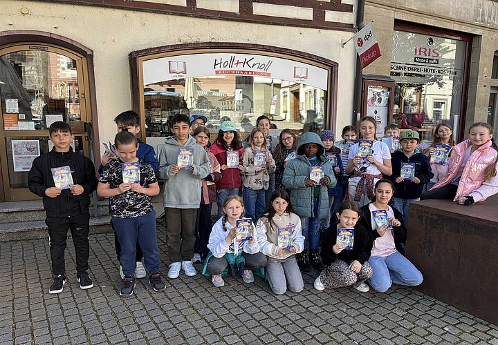 Schülerinnen und Schüler vor dem Buchladen Holl und Knoll mit ihrem Buchgechenk